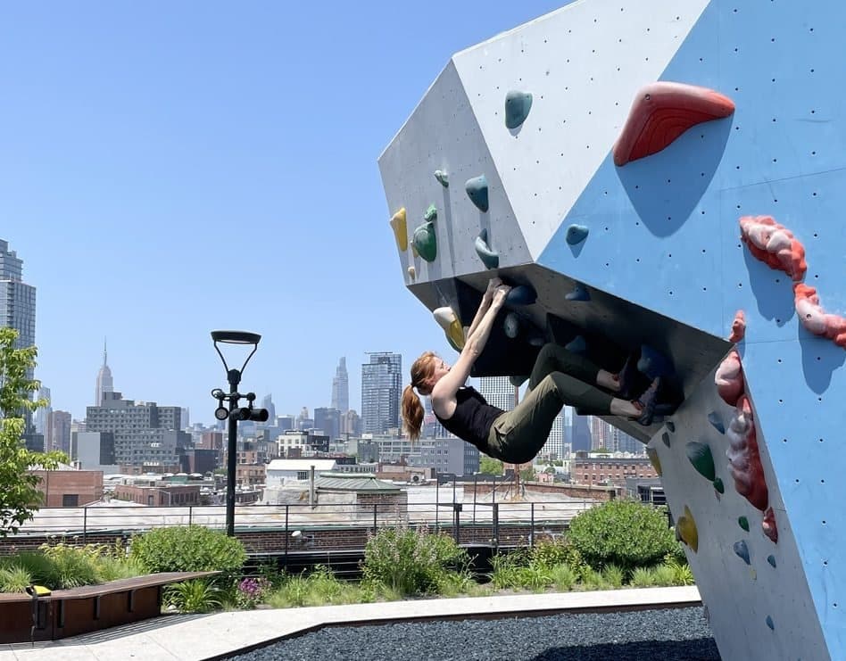 Bouldering on a rooftop with the Manhattan skyline behind